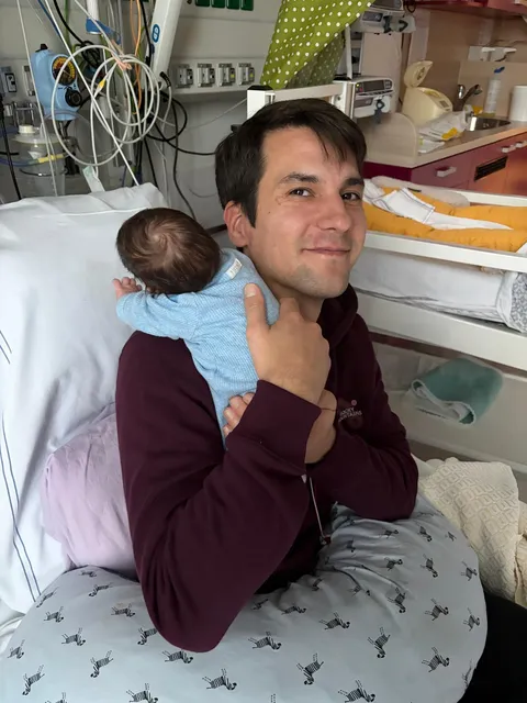 Frank met de kleine Stef tegen zijn schouder in de ziekenhuiskamer op de neonatologie